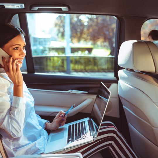 A photo showing a woman in a car talking on the phone